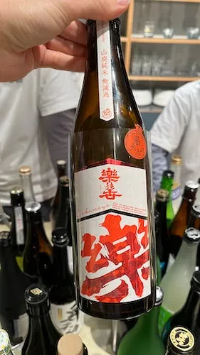Bottle of sake with white label and bright red kanji inscribed on it