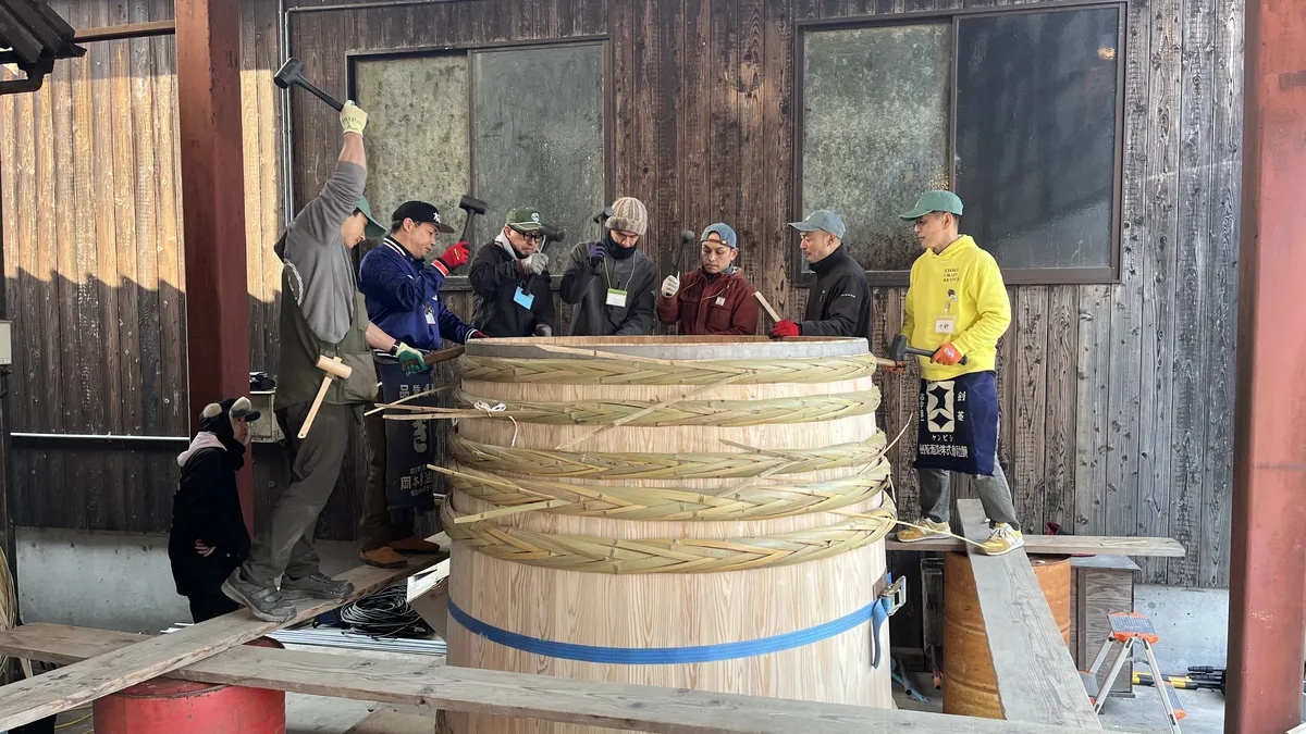 Hammering down the Taga loops, weaved using long strips of bamboo, to secure the walls of the Kioke.