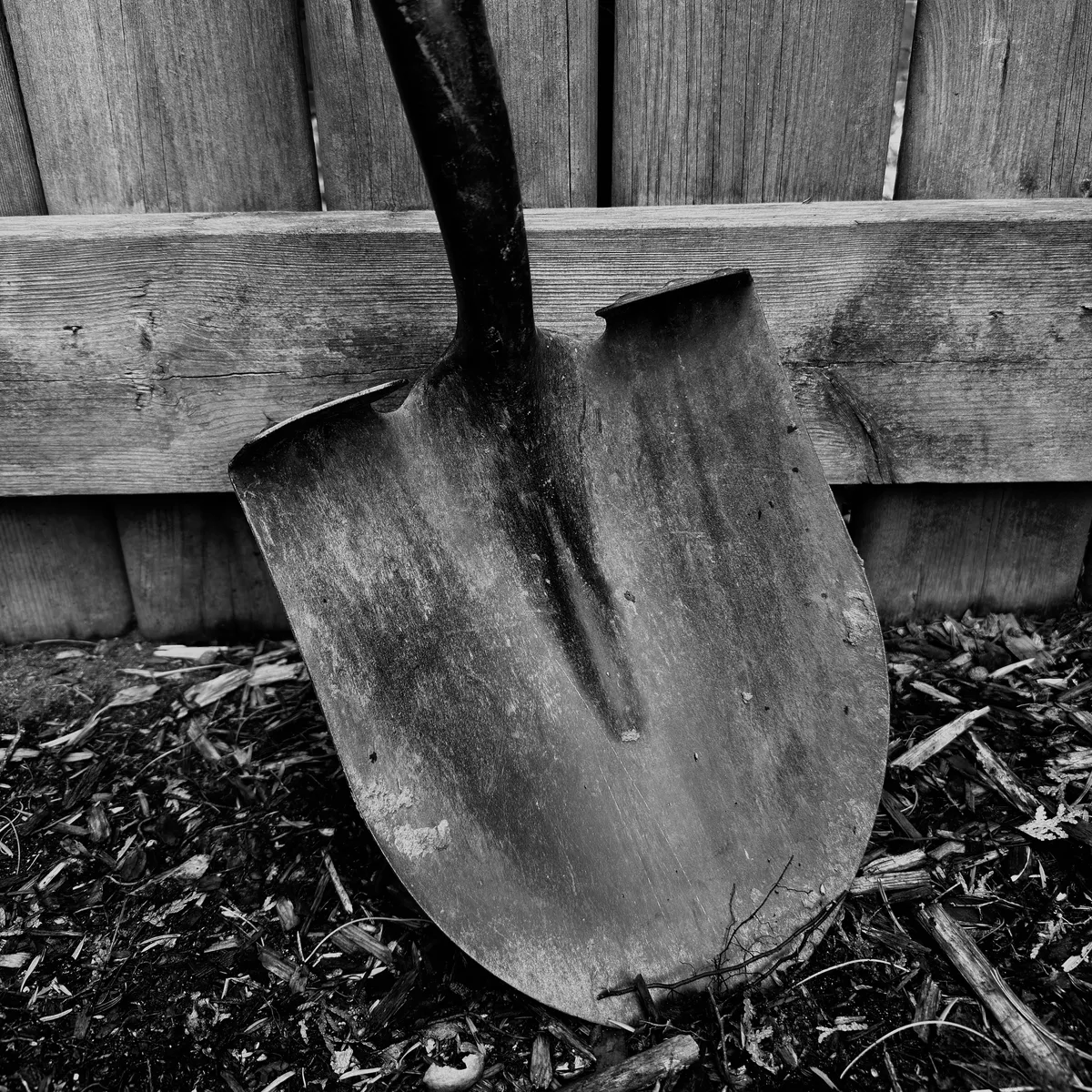 a shovel leaning on a fence