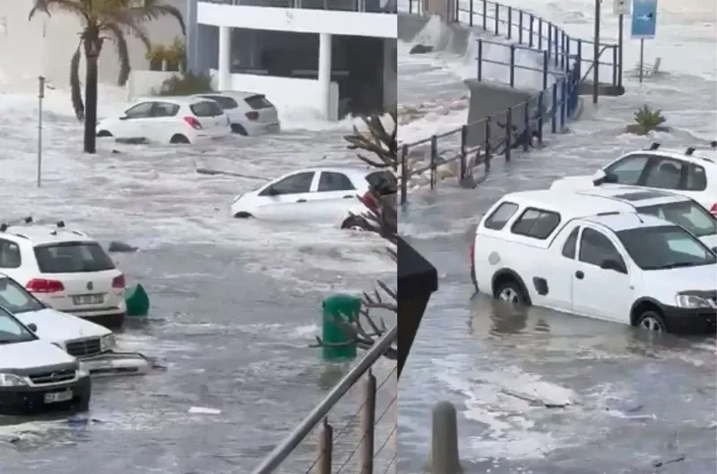 Cars submerged in floodwater in a coastal parking lot.