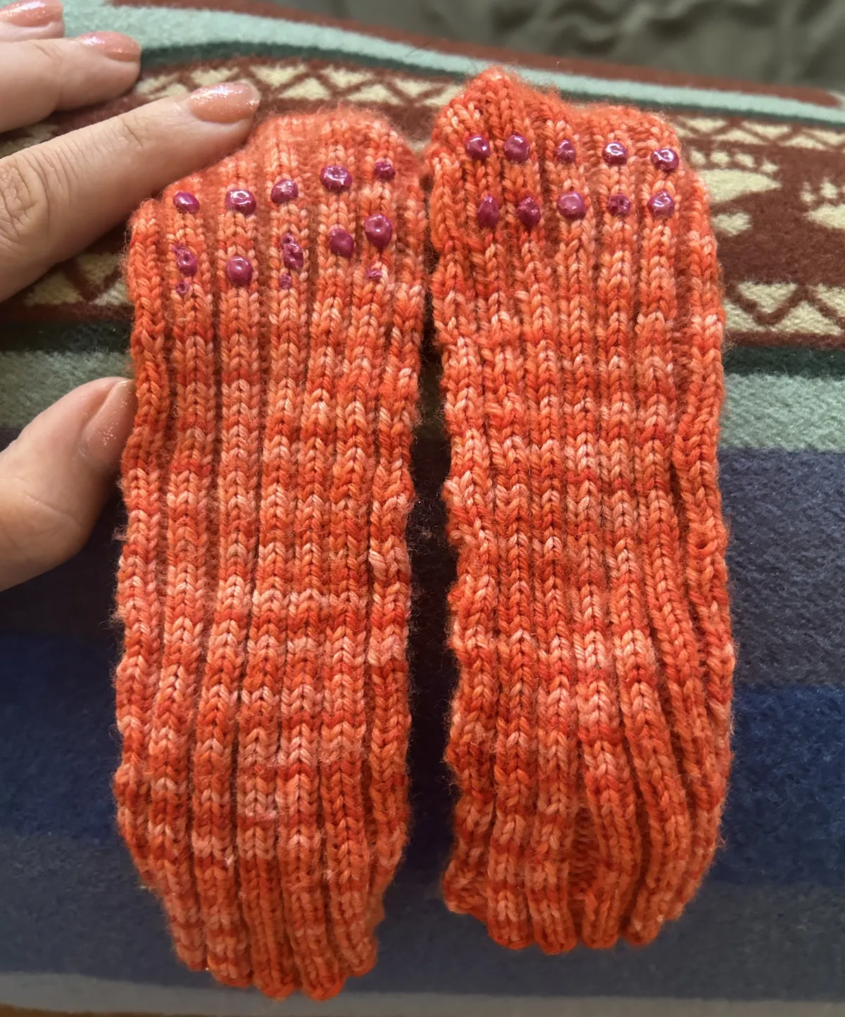 The back of the socks, which are ribbed with pink spots of what looks like paint glued on