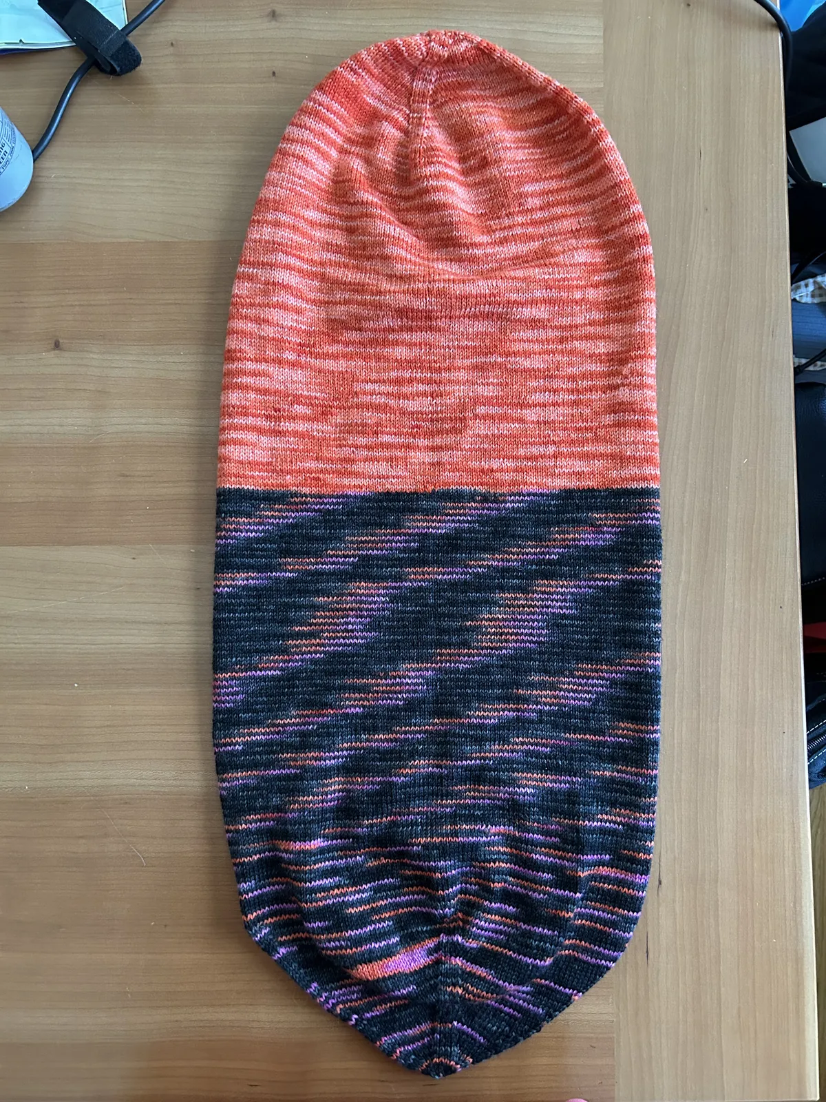 The beanie, orange and red, stretched out after blocking.