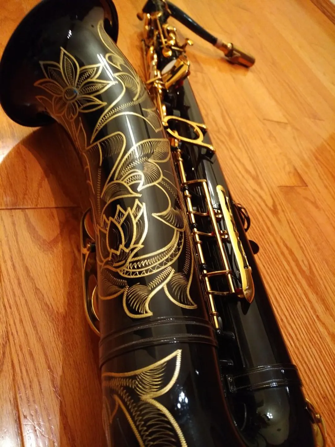 A saxophone with hand-carved artwork on the bell