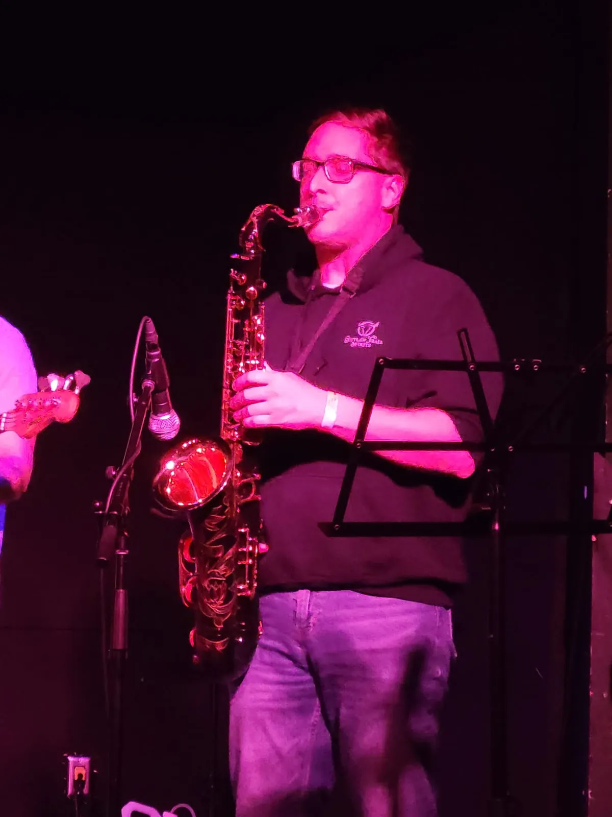 A person playing saxophone into a mic.