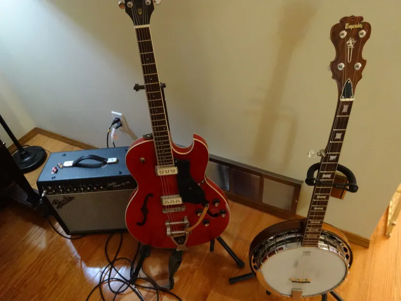 An electric guitar, amp, and a banjo