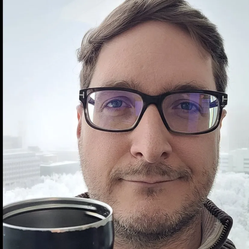 A person holding a coffee mug, posing for photo