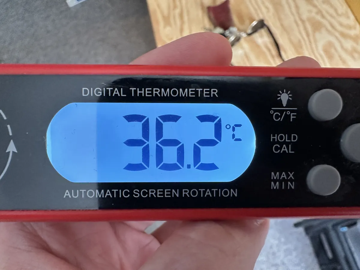 A thermometer showing its 36.2C (97.2F) inside my apartment