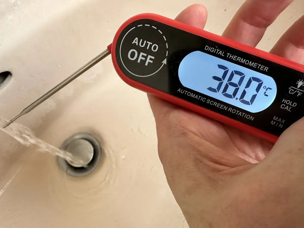 A thermometer showing my tap water is 38C (100.4F)