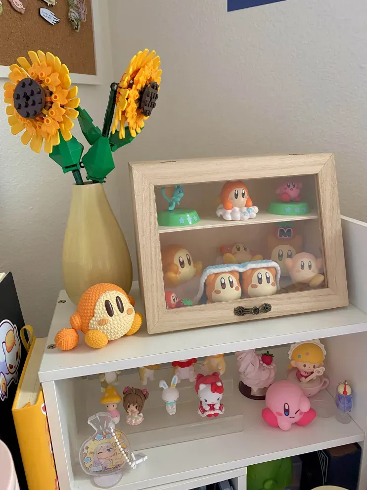An image with several Waddle Dee figures/trinkets sitting on a shelf