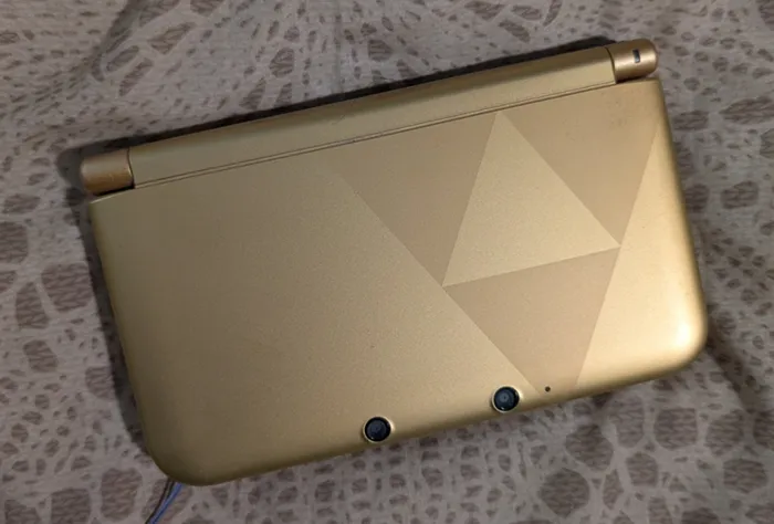 The front of my 3DS showing the Triforce on a gold surface