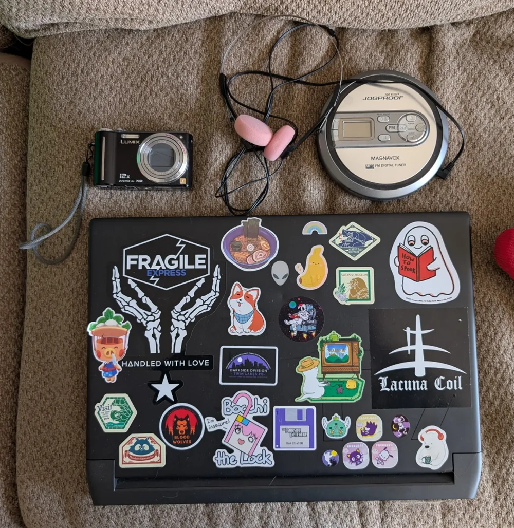 My laptop covered in stickers, Discman, and digicam