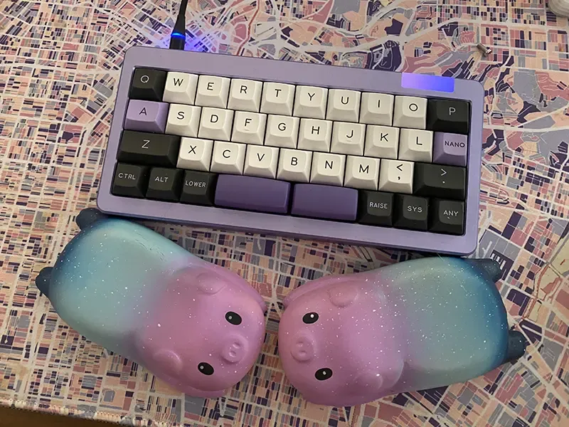 A small purple keyboard with galaxy pig wristrests