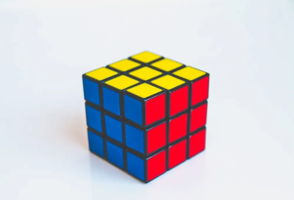 A solved Rubik's cube with yellow, blue, and red faces visible, representing the concept of a three-dimensional cube