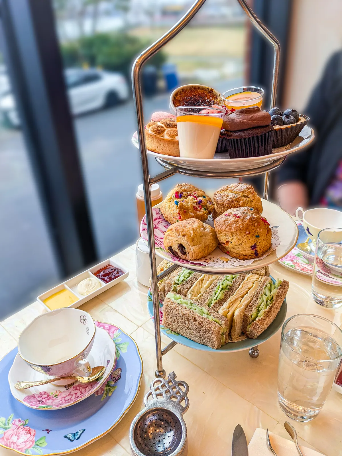 An afternoon tea stacker filled with scones, sandwiches, and pastries