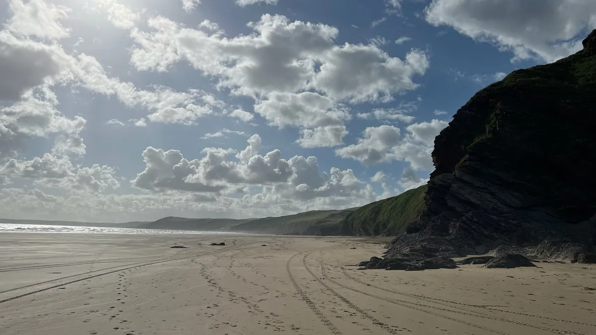 Views for miles along Tregantle Beach with white sand and sunny skies