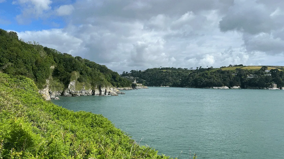 Turquoise blue sea view surrounded by cliffs covered with trees