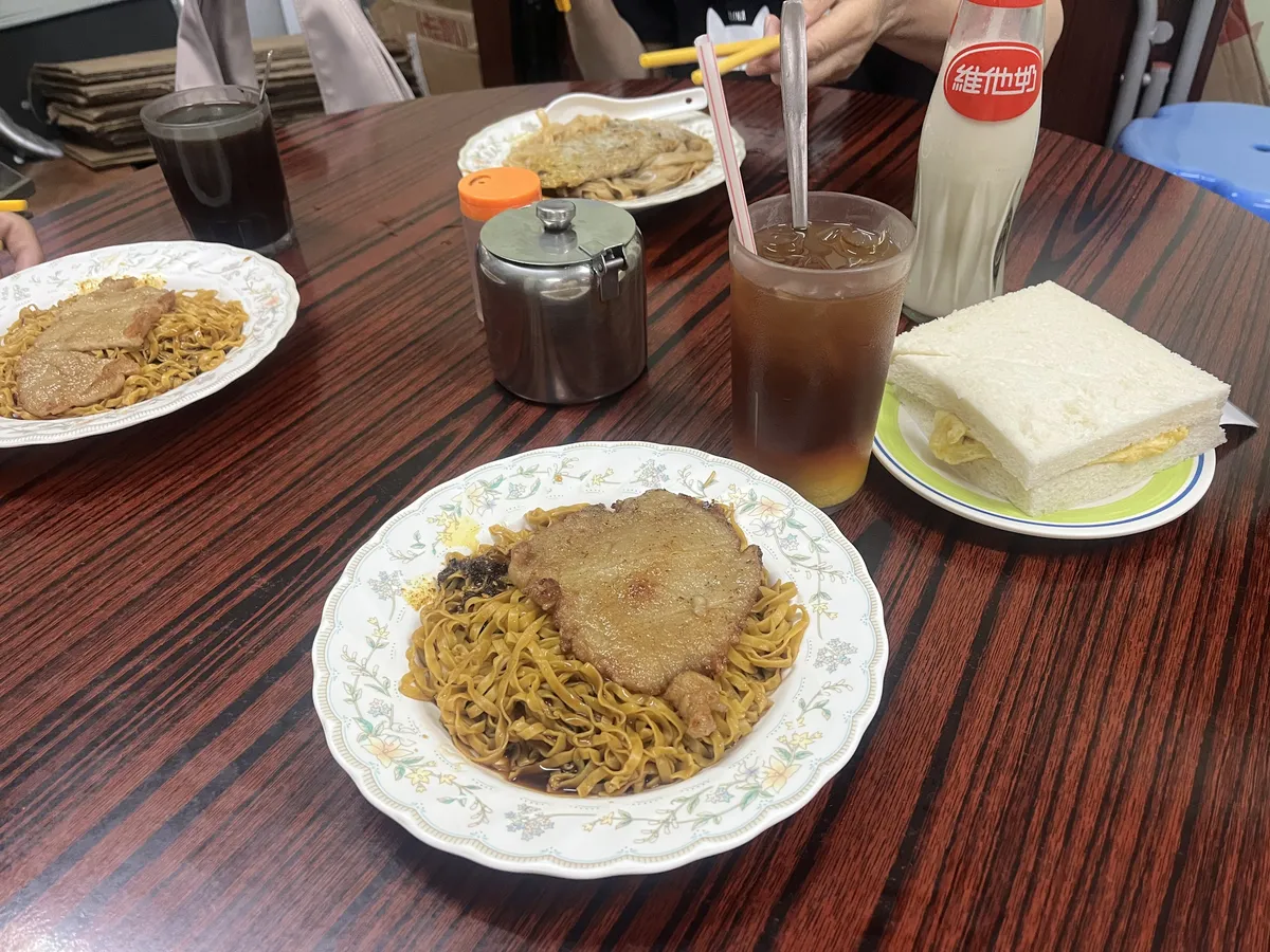 Spicy mixed noodles, lemon tea, egg sandwich, and vitasoy