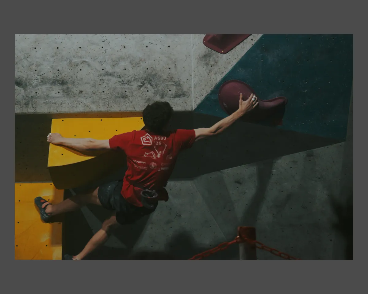 Another guy reaches up to a pink sloppy boulder