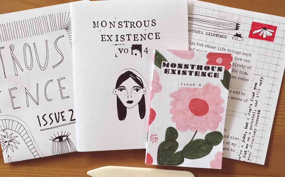 four colorful zines spread across a wooden table
