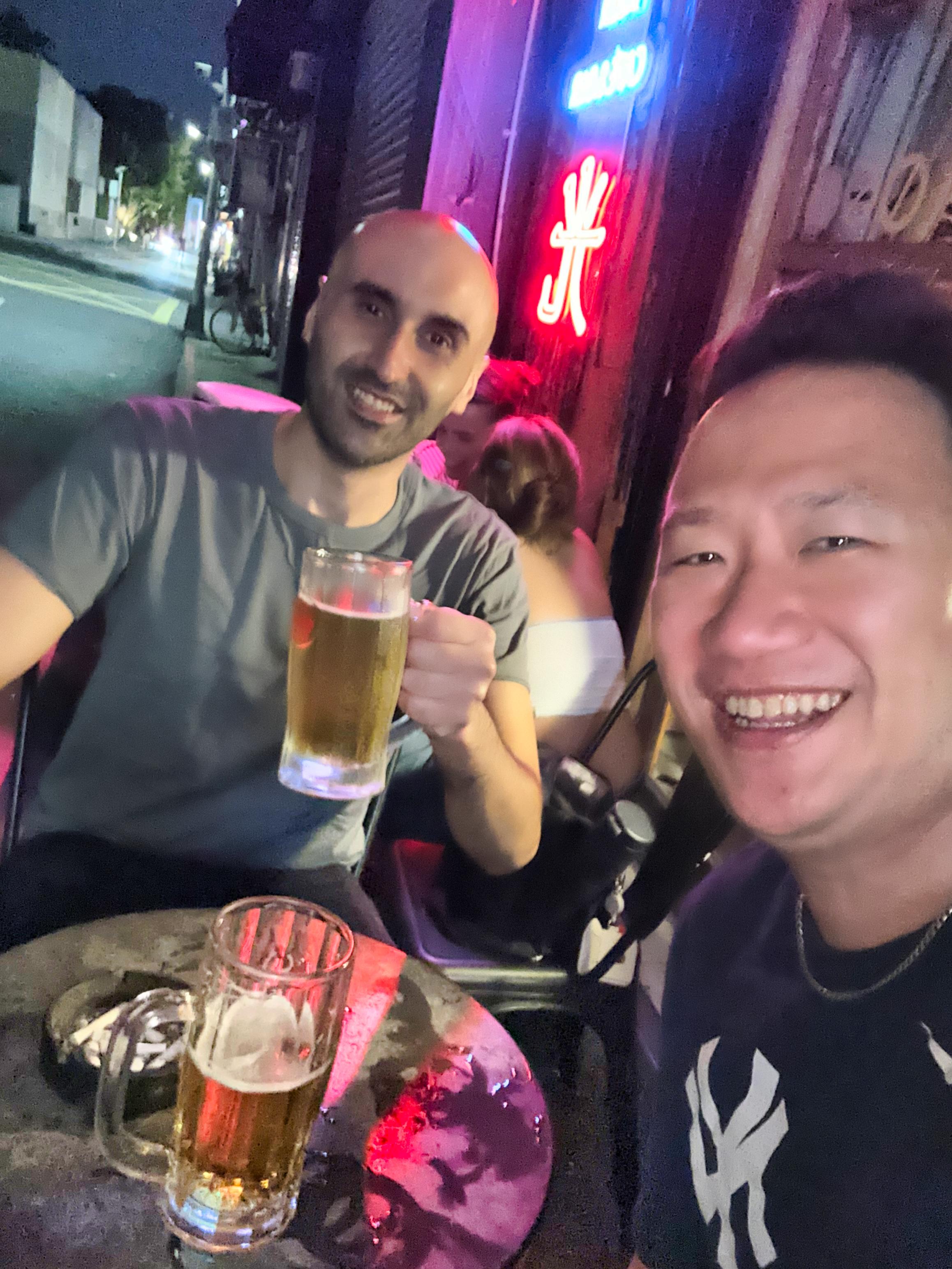two friends at an outside bar pose for a selfie