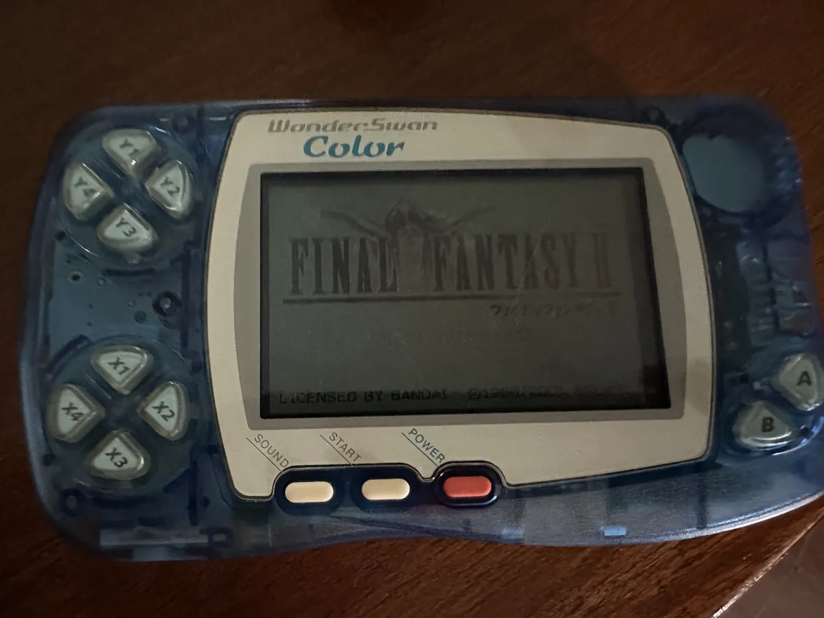 The WonderSwan outside the box. It's transparent blue and has with Final Fantasy II on screen.