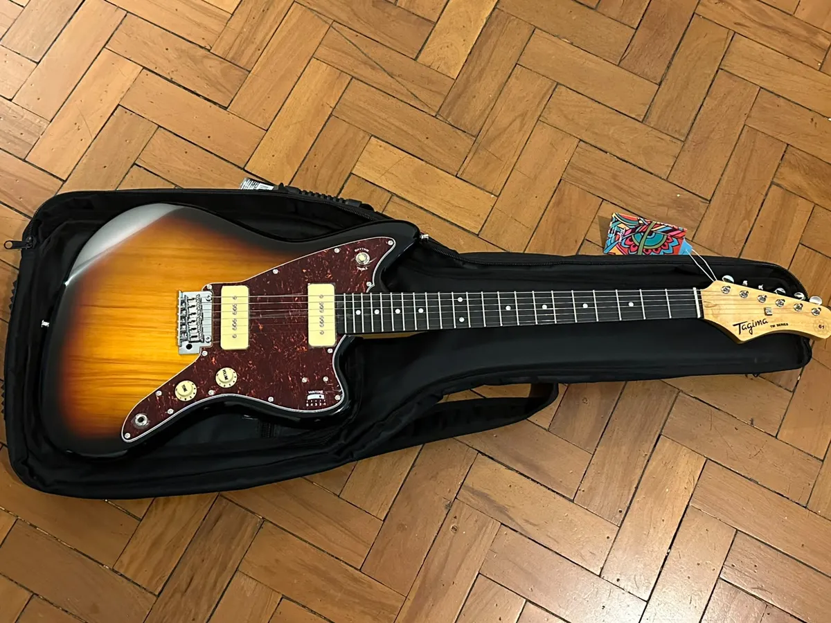A Tagima with a Jazzmaster body in sunburst color and tortoise shell pickguard.