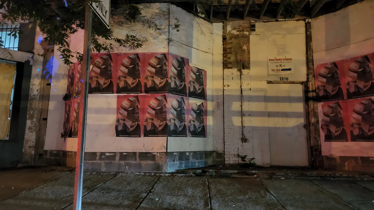 Event flyers and posters pasted on the side of a building at night in DC