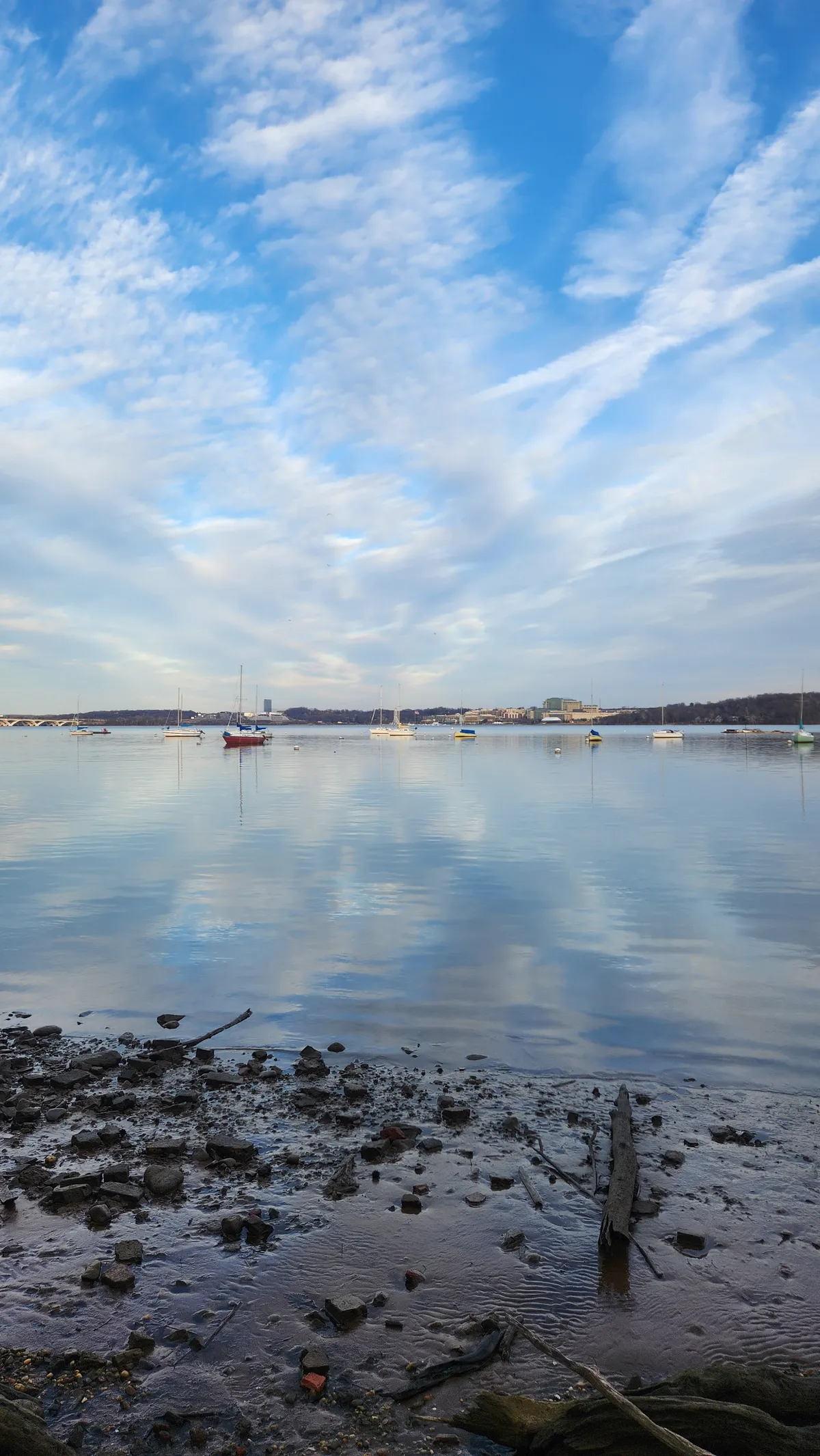 Sky reflected on water with collection of small boats