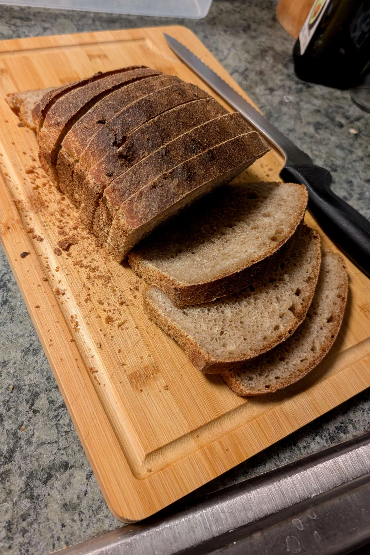 Photo of a sliced loaf of homemade bread on a wooden cutting board