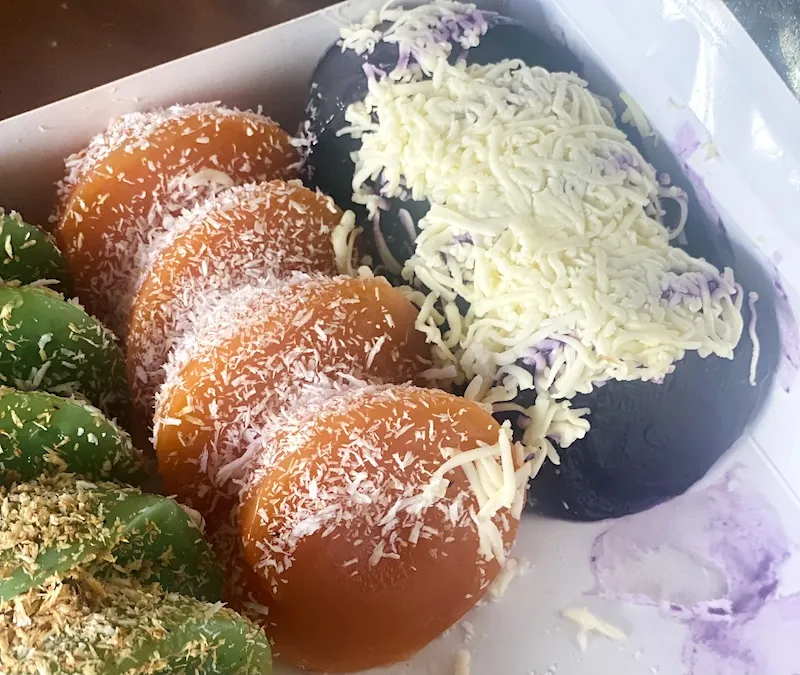Multicolored kutsinta in three flavors: pandan-pinipig (green), classic, ube-cheese (purple)