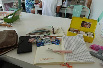 Table with journal and other stationery supplies spread out haphazardly DSC01428