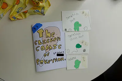 A booklet zine with an illustration of a chicken leg titled 'The Chicken Comic of Pokemon' and three illustrations of the Tamagotchi 'Kuchipachi' all hand drawn by a child.