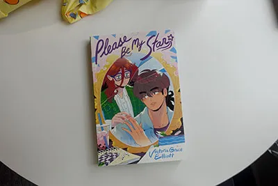 A comic book featuring a girl with glasses and a boy with their fingertips barely touching.
