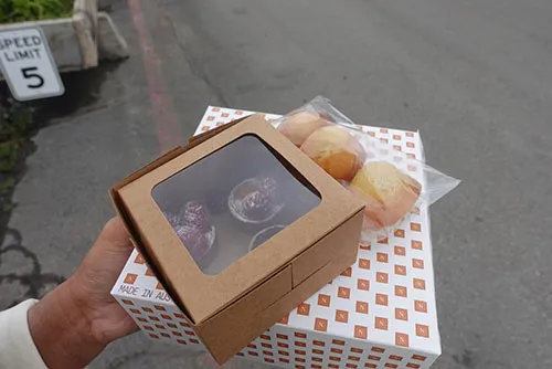 Boxes containing french pastries and plastic bag of madelines