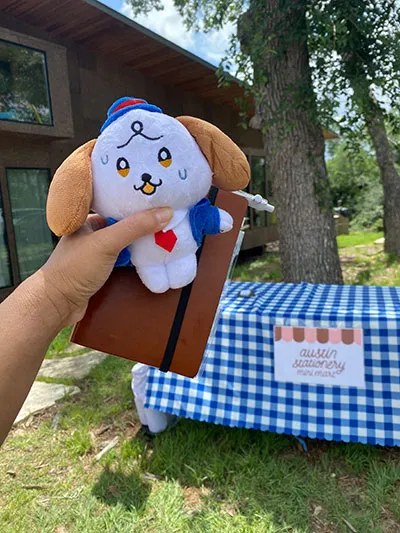 Plush doll with a table that says 'Austin Stationery Mini Mart' behind it. IMG_4265