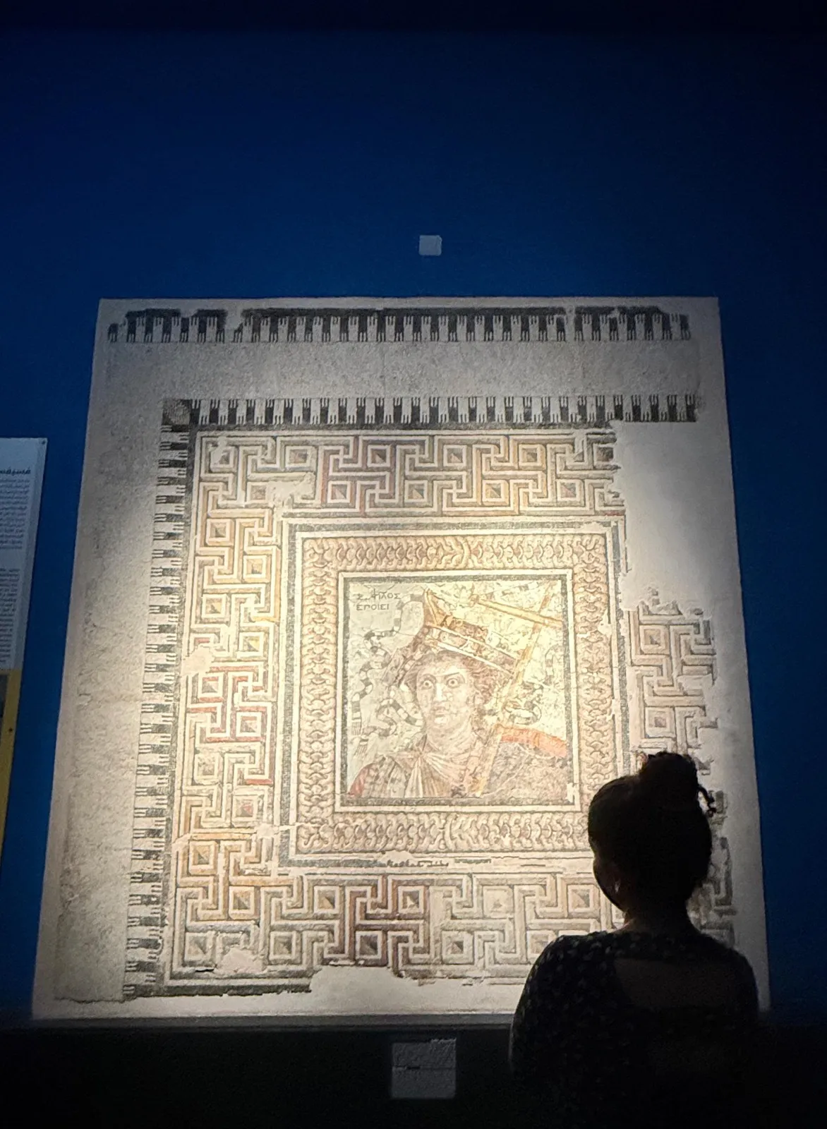 Zeina observing an artefact of a woman