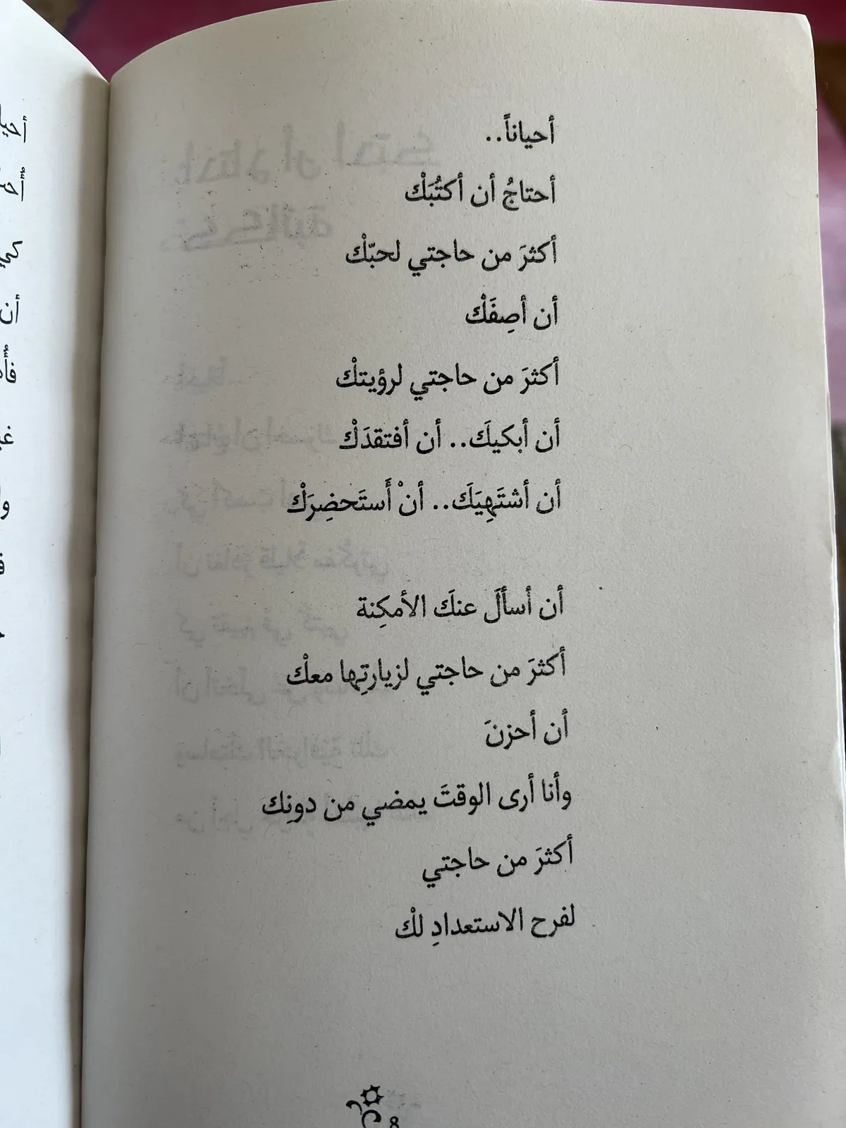 Open book showing an excerpt of a poem in Arabic