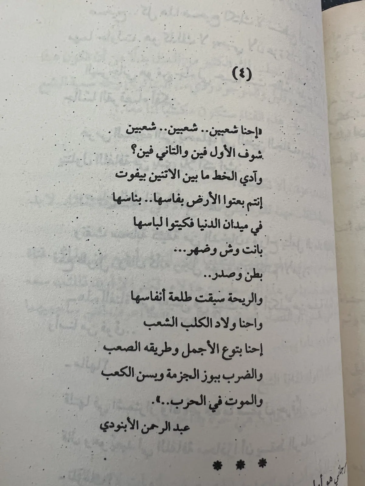 Open book showing an excerpt of a poem in Arabic