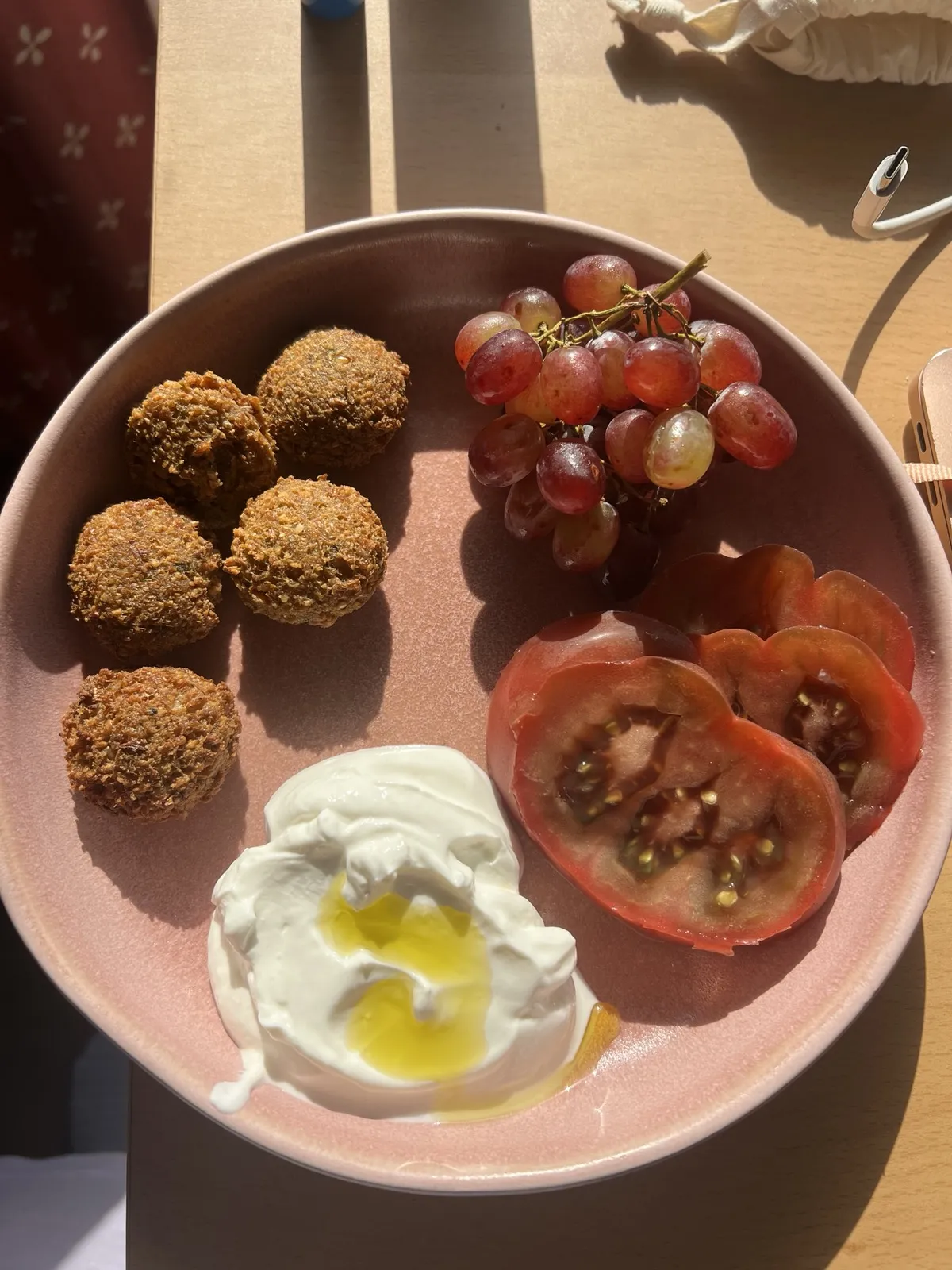 Breakfast plate of falafel, labneh, beef tomatoes and grapes