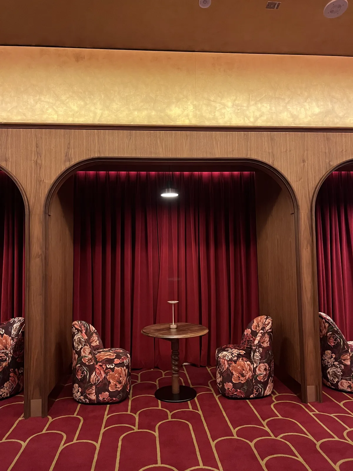 Cinema lounge with floral seating and red decor