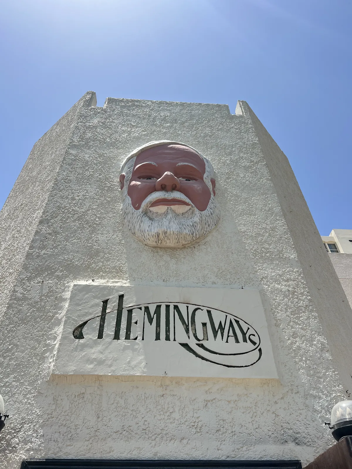 Entryway to Hemingway's bar with a sign displaying his haunting face