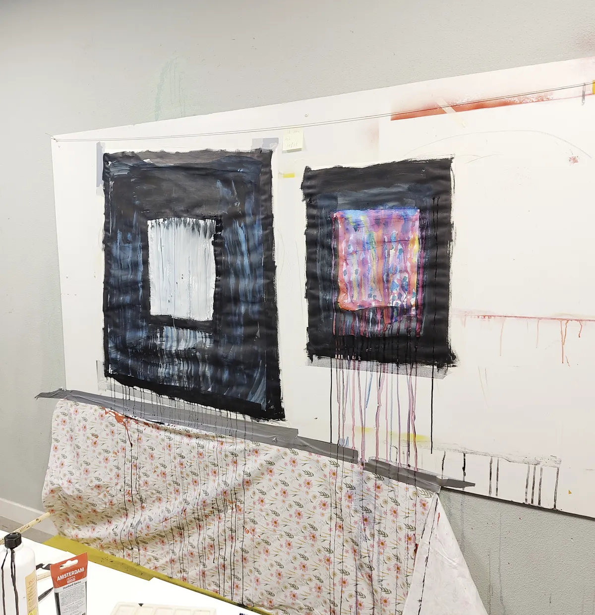 two smaller painting taped to a whiteboard